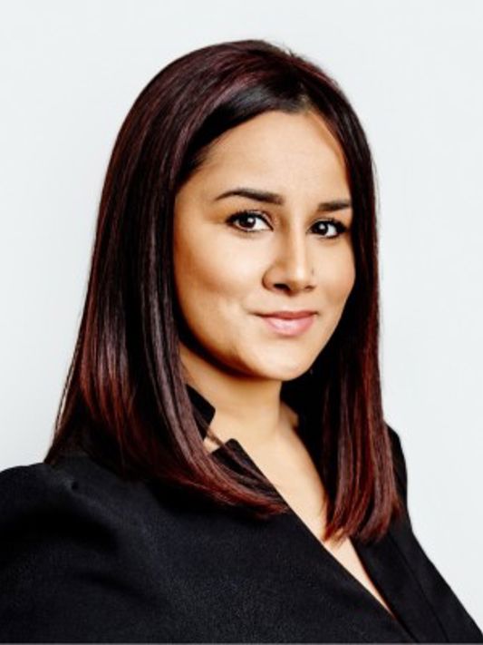 A headshot of Ameeta, a young professional brunette woman in a business suit